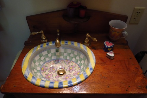 The hand=painted ceramic basin was dropped into an antique piece of furniture. 